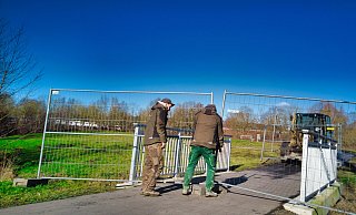 An dem Fußweg an der Emmer werden Bauzäune als Absperrungen aufgebaut. Die Fußgänger und Radfahrer werden durch den Schlosspark umgeleitet. - Wolfgang Furmanski