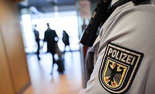Ein Beamter der Bundespolizei kontrolliert Reisende am Flughafen. - Christian Charisius/dpa/Symbolbild Ein Beamter der Bundespolizei kontrolliert Reisende am Flughafen. - Christian Charisius/dpa/Symbolbild