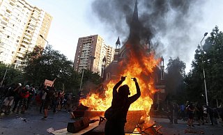 Regierungskritische Demonstranten verbrennen bei Protesten in Santiago M&ouml;bel aus einer chilenischen Polizeikirche. Chile erlebt seit Oktober anhaltende und teilweise gewaltt&auml;tige Stra&szlig;enproteste. - Foto: Luis Hidalgo/AP/dpa