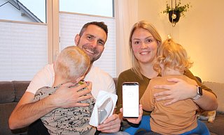 Dennis Zobel mit Sohn Emil, der mit knapp 13 Monaten an Diabetes Typ I erkrankt, und dem Sensor zur Messung des Gewebezuckers. Daneben Verena Zobel mit Tochter Leni und dem Handy, über das die aktuellen Zuckerwerte abgelesen werden können. - Freya Köhring(LZ)