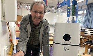 Der Hausmeister der Grundschule Kirchheide, Sebastian Bode, schließt eines der neuen Luftfilter-Geräte an. - Till Brand