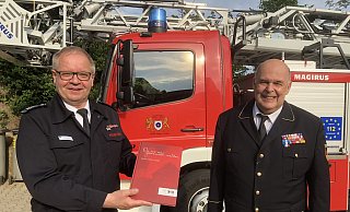 Stadtbrandinspektor Klaus Wegener (links) überreicht dem Leiter des Deutschen Feuerwehrmuseums, Rolf Schamberger, das erste Exemplar der Feuerwehr-Chronik. - Till Brand