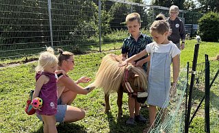 Anna Sowa (von links) fühlt sich mit Pony "Sophia" noch nicht ganz sicher. Ihre Mutter Katharina Schürhoff und ihre Geschwister Bruno und Polli Sowa streicheln das Pferd, während Anke Hackemack im Hintergrund schaut, dass nichts passiert. - Jan Schillmann