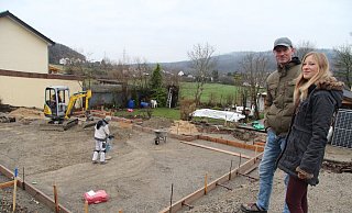 Svantje und Lars Heidemann stehen am Rand der Baugrube, wo zwei Arbeiter gerade den Untergrund für das Betonfundament ihres neuen Hauses vorbereiten. Bis Ende der Woche soll es gegossen sein. - Dieter Asbrock