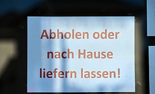 "Abholen oder nach Hause liefern lassen" steht in der Fensterfront eines Geschäftes. - Uwe Zucchi/dpa