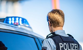 Eine Polizistin steht vor einem Streifenwagen. - David Inderlied/dpa/Illustration Eine Polizistin steht vor einem Streifenwagen. - David Inderlied/dpa/Illustration