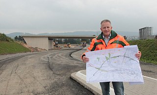 Projektleiter Dietmar Stölting erläutert die Pläne für die Barntruper Ortsumgehung. Im Hintergrund ist die Brücke zu sehen, die den VErkehr der B66n einmal über die Extertalstraße (L758) leitet. - Carolin Brokmann-Förster