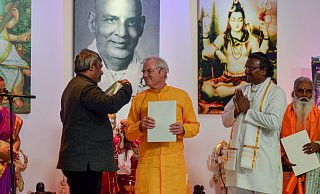 Der stellvertretende indische Botschafter Abhishek Dubey überreicht Yoga-Vidya-Gründer Sukadev Bretz den Ehrenschal. - Yoga Vidya
