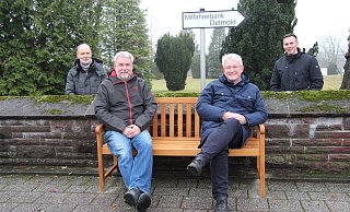 Frank Salomon (vorne links) und Bürgermeister Thomas Katzer sitzen Probe auf der neuen Mitfahrerbank an der Alten Dorfkirche in Augustdorf, während Wolfgang Huppke (hinten links) und Stefan Koop zusehen. - Nadine Uphoff