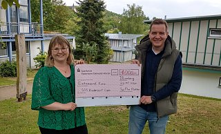 Tobias Nordmeyer übergibt den symbolischen Scheck an Laura Hesse vom SOS-Kinderdorf Lippe. - SynFlex Elektro GmbH