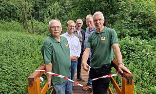 Rainer Pohl (von links), Borris Ortmeier, Werner Linneweber, Willi Düwel und Manfred Korf weihen die neue Brücke im Wald bei Alverdissen offiziell ein. - Nadine Uphoff