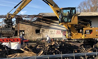 Nach wie vor bietet sich am Brandort an der Ladestraße ein apokalyptisches Bild. Während ein Bagger Schutt bewegt, spritzt Eugen Reiberg das Material ab, damit kein ungesunder Staub in die Luft gewirbelt wird. Fotos: Thomas Reineke - Thomas Reinke
