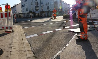 Arbeiter sind am Montagmittag dabei, der Straße den letzten Schliff zu verpassen. - Janet König