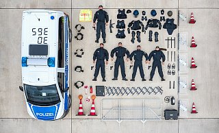 Bundespolizisten aus Duderstadt in Niedersachsen haben sich mit ihren Ausr&uuml;stungsgegenst&auml;nden neben ein Fahrzeug gelegt - und nehmen so an der #TetrisChallenge bei Instagram teil. - Foto: Sebastian Grafe/Bundespolizei