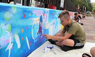 Roque Tietz malt sein Wassertier auf die farbenfrohe Mauer im Freibad Schieder. - Joline Heller Roque Tietz malt sein Wassertier auf die farbenfrohe Mauer im Freibad Schieder. - Joline Heller