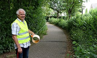 Abwasseringenieur Robert Blank h&auml;lt auf einem Fu&szlig;weg am Adlerweg ein Ma&szlig;band, an dessen Ende hinten vor der Hecke Ingenieur Matthias Kindsgrab steht. So lang wird die Maschine sein, mit deren Hilfe ein sogenannter Inlinerschlauch in den Kanal gezogen wird, der damit abgedichtet und stabilisiert wird. - Thomas Dohna