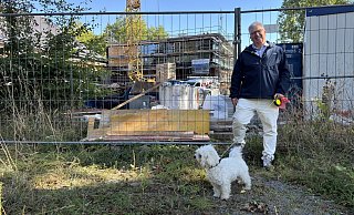 Dr. Johann Malcher steht mit Hund vor der Festhalle, die derzeit saniert wird. - Sven Kienscherf Dr. Johann Malcher steht mit Hund vor der Festhalle, die derzeit saniert wird. - Sven Kienscherf