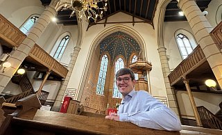 Tim Alexander sitzt in der Kilianskirche, im Hintergrund sieht man den Sternenhimmel im Altarraum. - Sven Kienscherf Tim Alexander sitzt in der Kilianskirche, im Hintergrund sieht man den Sternenhimmel im Altarraum. - Sven Kienscherf