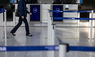 Eine Frau läuft an Lufthansa-Schaltern zum Check-In am Flughafen Düsseldorf vorbei. - Christoph Reichwein/dpa/Archivbild Eine Frau läuft an Lufthansa-Schaltern zum Check-In am Flughafen Düsseldorf vorbei. - Christoph Reichwein/dpa/Archivbild