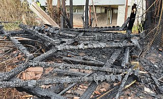 Verkohlte Holzreste zeigen, wo einst die Gartenhütte neben der Grundschule stand. Sie stand voll in Flammen und war nicht mehr zu retten. - Feuerwehr Barntrup