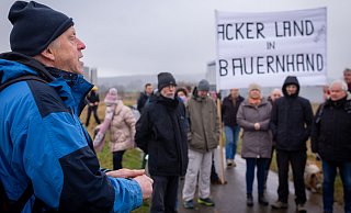 Auf Einladung von Hubert Weismantel (vorne) haben verschiedene zivilgesellschaftliche Akteure am Montag an der Bebauungsfläche des geplanten Amazon-Logistikzentrums ihre Bedenken hinsichtlich des Vorhabens geäußert. - Raphael Bartling