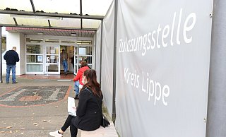 An der Zulassungsstelle müssen die Besucher aktuell vor der Tür warten, bis sie aufgerufen werden. Im September ist rechts und links ein Windfang in Form von großen Planen installiert worden. Nach hinten hin ist der Bereich aber offen. - Alexandra Schaller