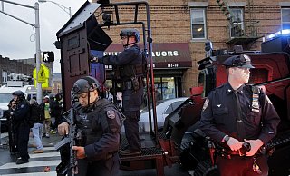 Schwer bewaffnete Polizisten sichern eine Stra&szlig;enecke in New Jersey. Bei einer stundenlang andauernden Schie&szlig;erei sind sechs Menschen ums Leben gekommen. - Foto: Seth Wenig/AP/dpa