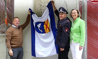 Bürgermeister Mario Hecker (von links), Ex-Löschgruppenführer Herbert Bröker und Ministerin Ina Scharrenbach enthüllen das Wandrelief aus der früheren Feuerwache. - Rudi Rudolph