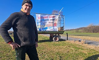 Ulf Allhoff-Cramer vor einem Plakat, das auf die Zerstörung durch den Klimawandel aufmerksam macht. - Carolin Brokmann-Förster
