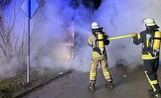 Feuerwehrleute löschen den brennenden Altkleidercontainer an der Mittelstraße in Dörentrup. - Feuerwehr Dörentrup Feuerwehrleute löschen den brennenden Altkleidercontainer an der Mittelstraße in Dörentrup. - Feuerwehr Dörentrup