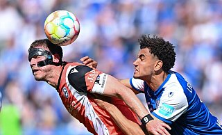 Magdeburgs Jamie Lawrence (r) und Bielefelds Fabian Klos kämpfen um den Ball. - Hendrik Schmidt/dpa