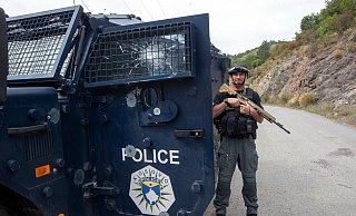 Ein Polizist aus dem Kosovo sichert das Gelände nach den schweren Kämpfen zwischen serbischen Paramilitärs und kosovarischen Polizisten. - Visar Kryeziu/AP/dpa Ein Polizist aus dem Kosovo sichert das Gelände nach den schweren Kämpfen zwischen serbischen Paramilitärs und kosovarischen Polizisten. - Visar Kryeziu/AP/dpa
