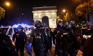 Polizisten patrouillieren vor dem Arc de Triomphe auf den Champs Élysées. - Christophe Ena/AP Polizisten patrouillieren vor dem Arc de Triomphe auf den Champs Élysées. - Christophe Ena/AP