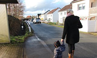 Die Birkenkampstraße ist schmal. Es gibt keinen Geh- oder Radweg für die Anlieger. Jana Strate muss mit ihrem Sohn daher aufpassen, wenn Autos vorbeifahren. - Nadine Uphoff