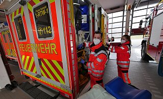 Mathias Brewe nimmt gerade einen Tragstuhl aus dem Rettungswagen. Damit werden Patienten Treppen herunter getragen. Seine Kollegin Michelle M&uuml;ller entfernt eine Schaufeltrage an der T&uuml;r, mit der Patienten schonend vom Boden aufgehoben werden k&ouml;nnen. - Jost Wolf