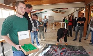 Die Bürger markieren die Stärken und Schwächen Schwalenbergs auf einem Luftbild mit farbigen Legosteinen. Til Reher (links), Mitarbeiter des Planungsbüros, steht ihnen zur Seite. - Michaela Weiße