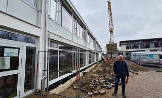 Fachbereichsleiter Chris Hütte-Getboga steht vor der alten Aula des Gymnasiums. Hier musste zuletzt eine neue Mauer gebaut werden. - Nadine Uphoff