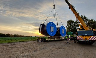 Ein Teil des neuen Hochbehälters wird vom Lkw mit einem Kran auf den Anhänger eines Treckers umgeladen. - Stadtwerke Lemgo