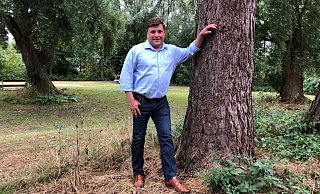Jan Gentemann steht im Park am ehemaligen Jugendzentrum "Das Haus" in Holzhausen. Auf der anderen Seite der Max-Planck-Straße befindet sich sein Autohaus. - Thomas Reineke(LZ)