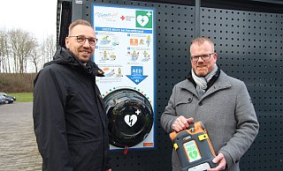 Mike Wittsieker (links) von der Verwaltung und Bürgermeister Friso Veldink stehen vor einem der neuen Defibrillatoren, der außen am Gelände des Rathauses angebracht ist. - Nadine Uphoff Mike Wittsieker (links) von der Verwaltung und Bürgermeister Friso Veldink stehen vor einem der neuen Defibrillatoren, der außen am Gelände des Rathauses angebracht ist. - Nadine Uphoff
