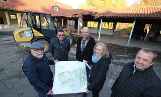 W&auml;hrend im Hintergrund der Bagger schon Teile des Dachs in Angriff genommen hat, zeigen SPD-Fraktionschef Manfred Rehse (von links), CDU-Ratsherr Olaf Copony, Fachbereichsleiter Olaf Kapelle, Bauamts-Architektin Ute Seidemann und B&uuml;rgermeister Mario Hecker den Plan f&uuml;r die k&uuml;nftige Gestaltung des Grundschul-Gel&auml;ndes in Hohenhausen. - Jens Rademacher