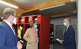Bürgermeister Borris Ortmeier (links) und Fachbereichsleiter Chris Hütte-Getboga zeigen Ministerin Ina Scharrenbach, wie das Fördergeld in der Feuerwache verwendet wurde. - Astrid Sewing