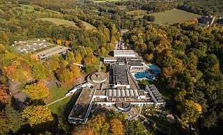 Die „VitaSol“-Therme aus der Vogelperspektive. Das neue Hotel soll auf einem Teil des Hauptparkplatzes (hinten) entstehen. Um den Verlust der Stellflächen auszugleichen, soll ein zusätzliches Parkdeck auf der Flachsheide (links im Bild) errichtet werden. Die Grenze zum Wohnmobilhafen wird als Sichtschutz begrünt. - VitaSol-Therme
