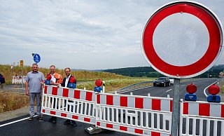 Randolf Büscher (Leiter Straßenmeisterei Schieder, von links), Tobias Fischer (Straßen.NRW) und Bürgermeister Borris Ortmeier stehen vor dem noch gesperrten Teilstück. Nur kurze Zeit später wurden die gut 900 Meter für den Verkehr freigegeben. - Lorraine Brinkmann
