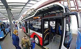 Der rot-weiße Elektrobus macht auf seiner Probefahrt Halt am Treffpunkt. Manche Fahrgäste sind sich wegen der fehlenden blauen Lackierung unsicher, ob er die reguläre Stadtbus-Linie 2 fährt.  - Nicole Ellerbrake