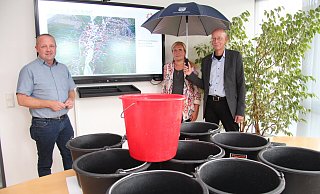 Bürgermeister Mario Hecker (von links), Gemeindemitarbeiterin Corinna Will und Rüdiger Kuhlemann vom Kreis Lippe beim Vortrag zum Thema "Wasser in der Krise". Die Eimer sollen verdeutlichen, wie viel Regen auf einen Quadratmeter bei einem Starkregenereignis innerhalb kürzester Zeit fallen kann. - Nadine Uphoff Bürgermeister Mario Hecker (von links), Gemeindemitarbeiterin Corinna Will und Rüdiger Kuhlemann vom Kreis Lippe beim Vortrag zum Thema "Wasser in der Krise". Die Eimer sollen verdeutlichen, wie viel Regen auf einen Quadratmeter bei einem Starkregenereignis innerhalb kürzester Zeit fallen kann. - Nadine Uphoff