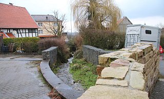 Wo einst eine Brücke über den Holzhauser Bach führte, verhindern jetzt Gabionen, dass man ins Wasser fällt. In diesem Bereich kann sich der SPD-Ortsverein einen Rastplatz für (Rad-)Wanderer vorstellen, der auch gleichzeitig als Dorftreffpunkt dienen soll. - Dieter Asbrock
