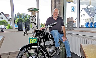 Geschäftsführer Volker Siekmann (58) sitzt auf der alten DKW seines Großvaters, die er zusammen mit der alten BP-Zapfsäule als Dekoration in die Raststätte gestellt hat. - Gunter Held Geschäftsführer Volker Siekmann (58) sitzt auf der alten DKW seines Großvaters, die er zusammen mit der alten BP-Zapfsäule als Dekoration in die Raststätte gestellt hat. - Gunter Held