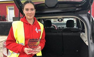 Jana Diser zeigt steht an ihrem Auto, in der Hand hält sie die Auszeichnung als „Heldin der Straße", die sie für ihren Einsatz im vergangenen Juni bekommen hat. - Sven Kienscherf