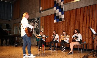 Musiklehrer Phillip Meyer und einige Schülerinnen an der Gitarre. - Realschule Lemgo Musiklehrer Phillip Meyer und einige Schülerinnen an der Gitarre. - Realschule Lemgo